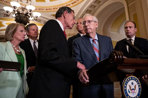 WASHINGTON, DC - JULY 26: (L-R) Sen. John Barrasso (R-WY) reaches out to help Senate Minority Leader Mitch McConnell (R-KY) after McConnell froze and stopped talking at the microphones during a news conference after a lunch meeting with Senate Republicans U.S. Capitol 26, 2023 in Washington, DC. Also pictured, L-R, Sen. Shelley Moore Capito (R-WV), Sen. Steve Daines (R-MT), and Sen. John Thune (R-SD). McConnell was escorted back to his office and later returned to the news conference and answered questions.  (Photo by Drew Angerer/Getty Images)