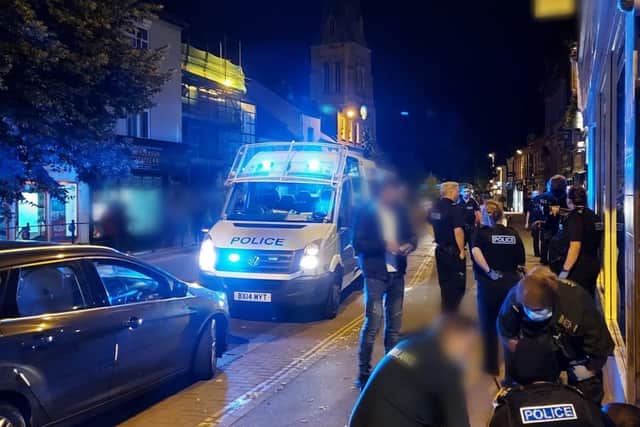 Pictures show a fleet of police vehicles parked up and down the High Street as people spilt out into the road.