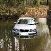 A BMW has been left marooned in deep water on a picturesque country road near Market Harborough.