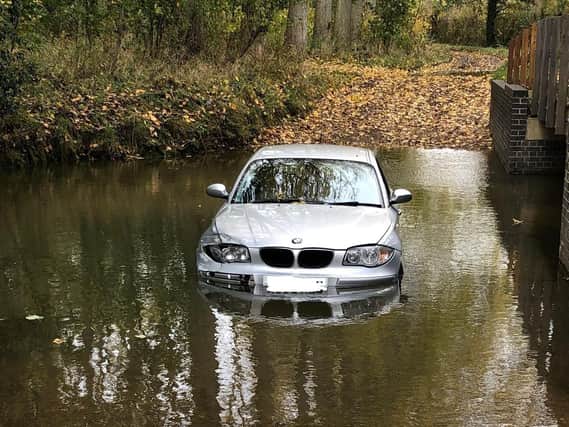 A BMW has been left marooned in deep water on a picturesque country road near Market Harborough.