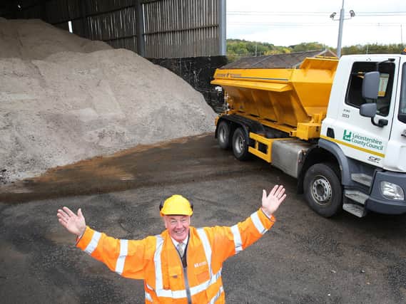 Cllr Trevor Pendleton at Leicestershire County Council's Mountsorrel highways depo with their salt supply and one of their gritters.