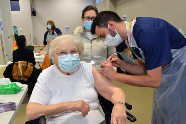 Sheila Thomas, 90, of Lutterworth, receives her Covid vaccine from general practice trainee Ravi Masharani at the Kube in Leicester.
PICTURE: ANDREW CARPENTER