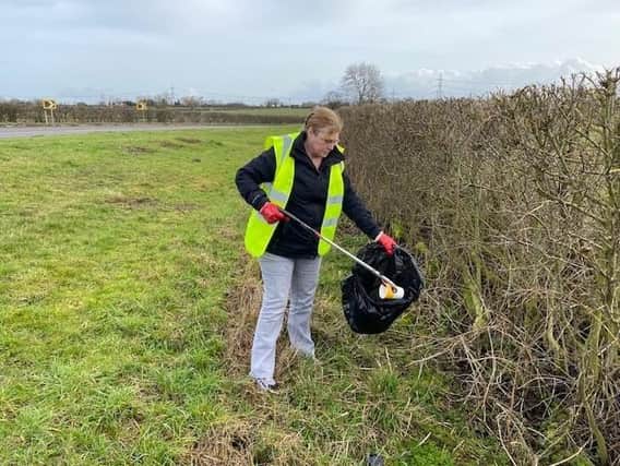 Cllr Louise Richardson, the county council’s cabinet member for communities, picking litter in the countryside.