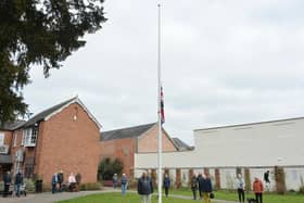 People stand for a minute silence at the memorial gardens at noon to remember those who died of Covid over the past year.
PICTURE: ANDREW CARPENTER