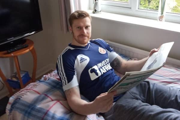 Brad Williams reads his story in the Harborough Mail from the comfort of his home
