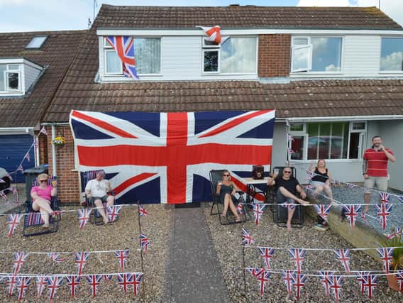 Michael Crook of Willow Crescent celebrates VE Day with his huge union jack flag and neighbours.
PICTURE: ANDREW CARPENTER