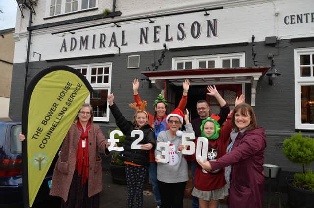 Carol Tilley (centre) hands over £2,360 to Patricia Gibbard and Cara Thompson of The Bower House with help from Jess Brightwell, 10, Alison Shakeshaft, Tim Richards landlord and Charlie Tilley, 9.
PICTURE: ANDREW CARPENTER