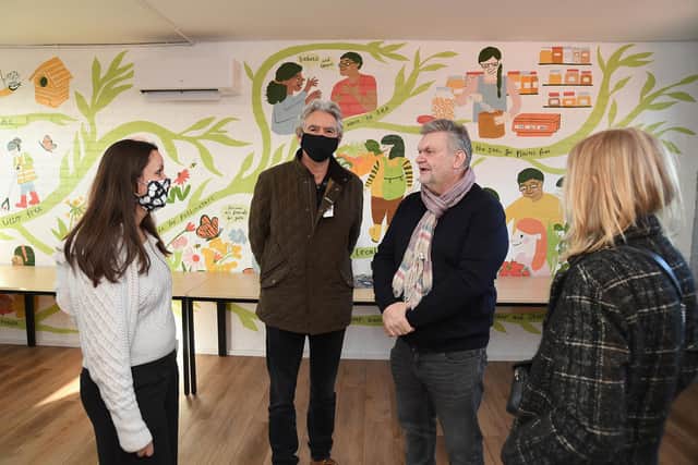 Photographer Mark A Phillips (centre) during his exhibition at the EcoVillage.
PICTURE: ANDREW CARPENTER