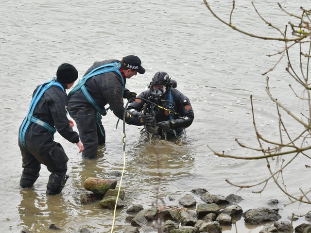 Members of the underwater search team assist the diver at the River Witham. EMN-220203-142912001