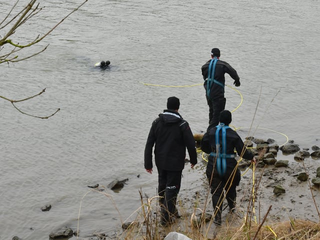 The diver submerged under the waters of the River Witham as other officers assist.