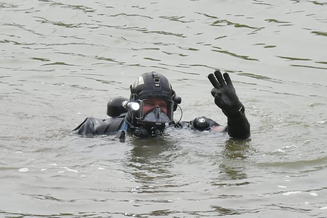 The police divers signals to his colleagues back on the river bank.