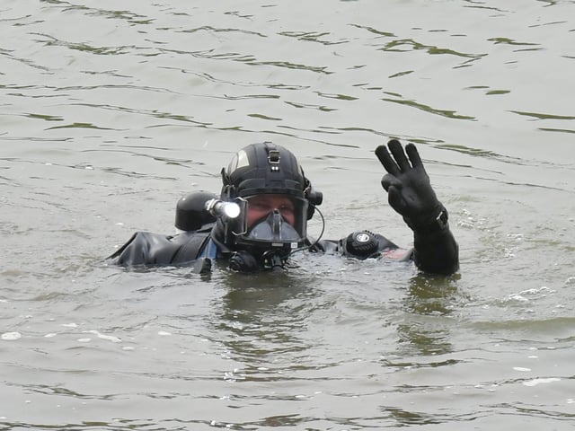 The police divers signals to his colleagues back on the river bank.