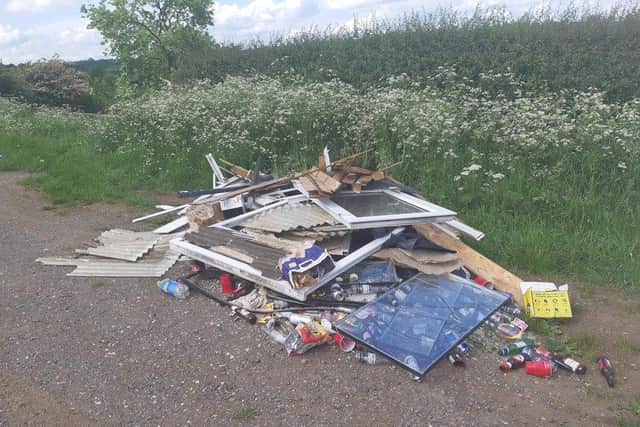 Fly-tippers have piled up a stack of building waste, including window frames, as well as beer bottles and other rubbish on Mowsley Road, Saddington, near Fleckney.