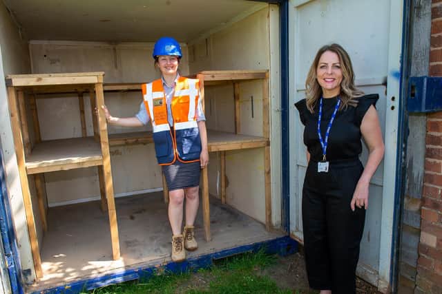 Gina Mayfield and Kate Jones with the metal storage container donated by David Wilson Homes