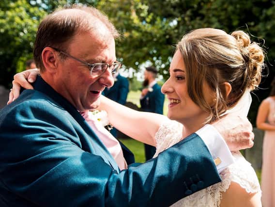 Caption: Kathryn and her father Kevin Abraham hug at her wedding in 2017.