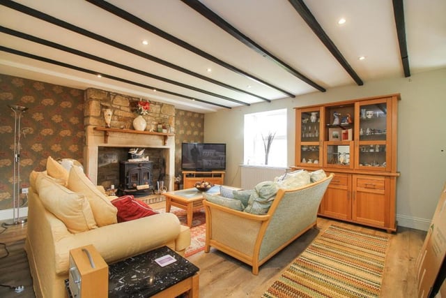 A sizeable yet cosy living room that benefits from a feature inglenook-style fireplace, log burner and exposed beams.