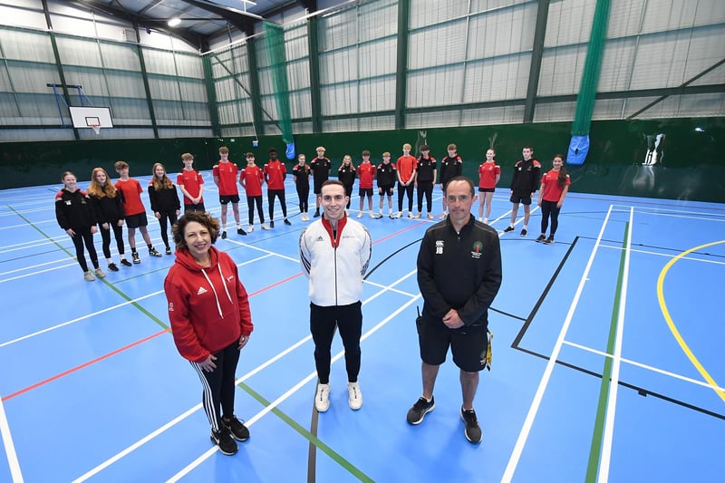 Nada Hankin, Andrew Stamp and PE teacher Jason Button inside the sports hall with some students at Welland Park Academy.