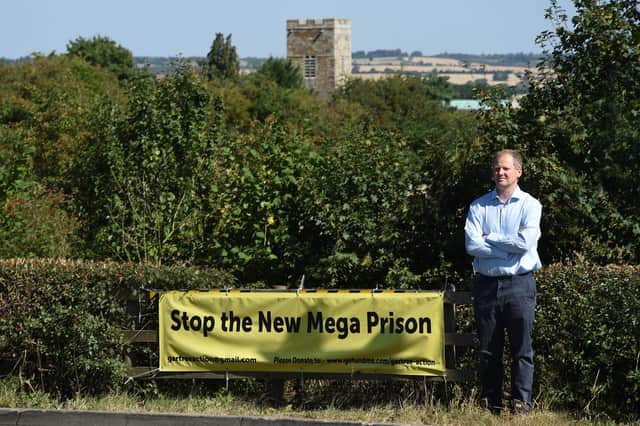 Neil O'Brien MP with the banner near Gartree prison.
PICTURE: ANDREW CARPENTER