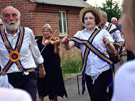 The Braybrooke Morris dancers performing a variety of traditional hankie and stick dances outside the Bulls Head at Arthingworth.
