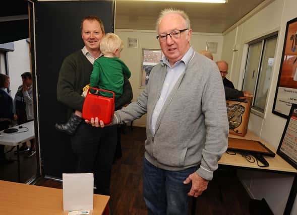 Volunteer David Leyland is give a radio to fix by Neil O'Brien. Photo by Kerry Davies