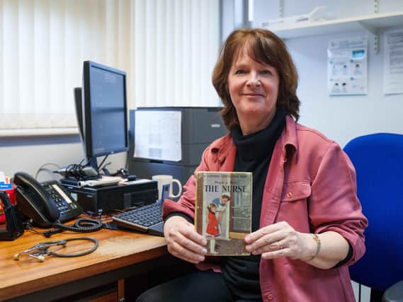 Dr Eardley with 'People at Work: The Nurse, 1963' - a book she says inspired her.