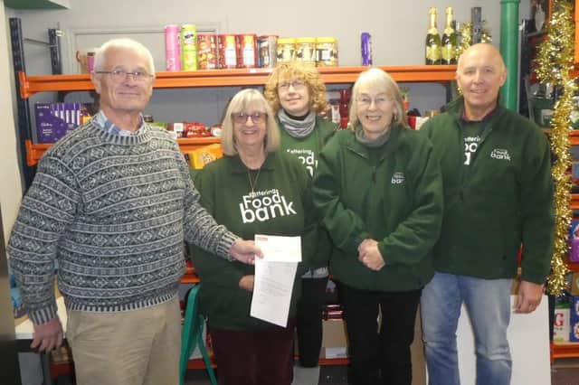 The choir's secretary, Trevor Mason, visited Kettering Food Bank at their base to present a cheque of £500 to Jane Calcott (centre, back) and some her fellow volunteers.