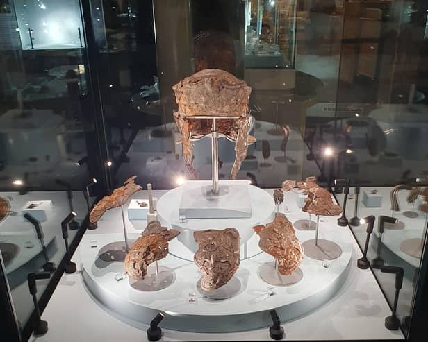 The Hallaton Helmet displayed with helmet cheekpieces and other objects found buried with it.