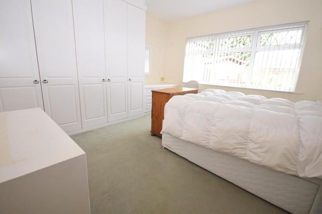 The main double bedroom at the Oakwood Drive bungalow is a substantial size. It features a useful, fitted wardrobe and dressing table, plus a radiator and a uPVC window facing the back of the property.