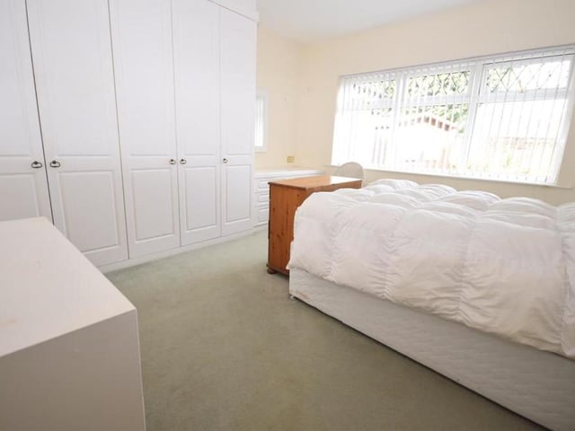 The main double bedroom at the Oakwood Drive bungalow is a substantial size. It features a useful, fitted wardrobe and dressing table, plus a radiator and a uPVC window facing the back of the property.