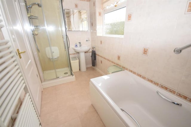 The bathroom comprises a modern four-piece suite that includes a panelled bath, separate shower cubicle, wash basin and low-flush WC. It is smartly decorated, with tiled walls and a heated towel-rail.