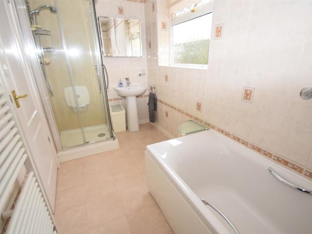 The bathroom comprises a modern four-piece suite that includes a panelled bath, separate shower cubicle, wash basin and low-flush WC. It is smartly decorated, with tiled walls and a heated towel-rail.