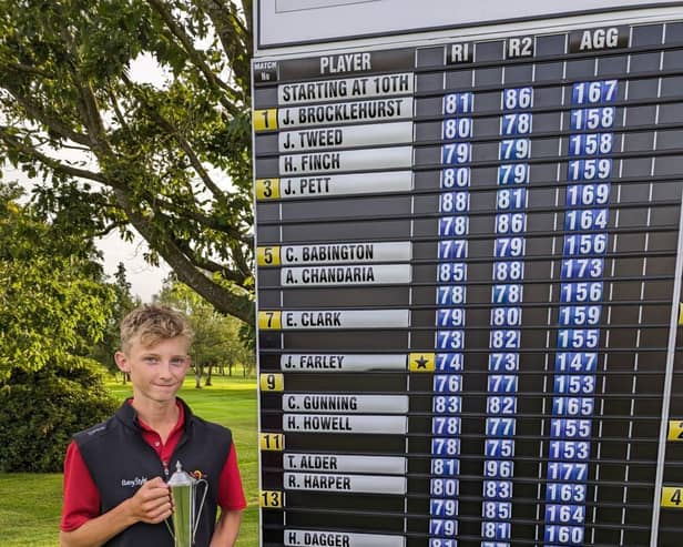 Jack with his trophy in front of leaderboard