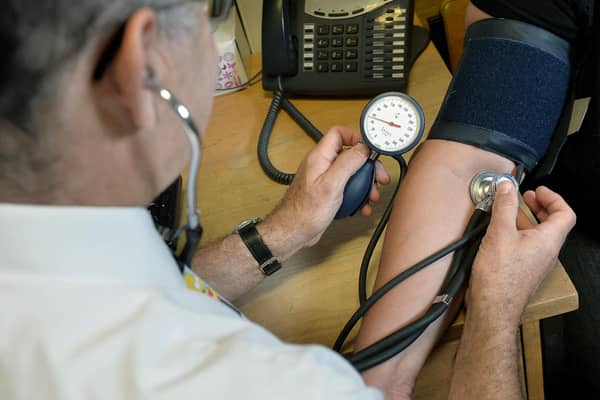 A GP checking a patient's blood pressure.
