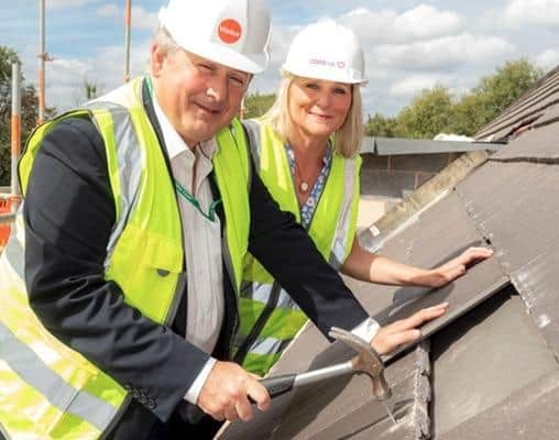 Cllr Phil King and regional director of Care UK, Dianna Coy, placing last tile on the roof