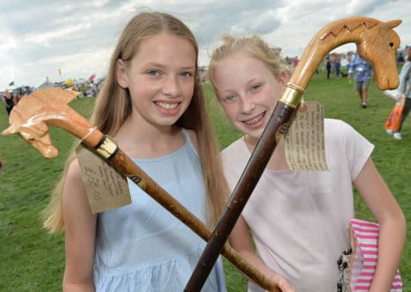 Ella Barney 14 and Grace Williams 11 with carved walking sticks at the County Show.
PICTURE: ANDREW CARPENTER NNL-170829-153238005