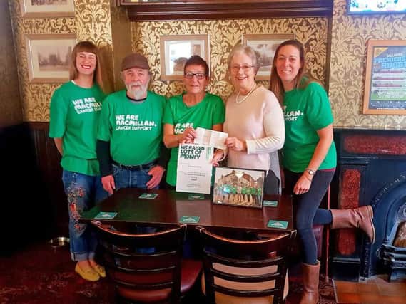 Centre, Carole Tilley presents the cheque to Eunice Loney Chairman of Market Harborough Group of Macmillan Cancer Support at the Nags Head with some of the friends who took part.