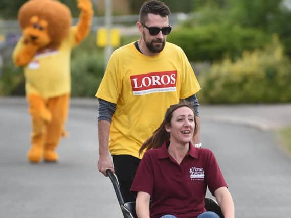 Hollie Jaffer of Home Instead gets help from a Loros supporter. PICTURE: ANDREW CARPENTER
