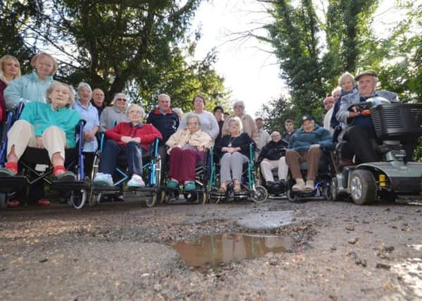 Residents of St Mary's House in Lutterworth with the potholed road