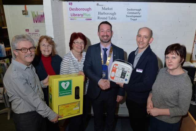 Life saver..Philip Rice chairman, Marie Lacey and Shelagh Hodder of the friends of Desborough library, Jeremy Wilkinson president of Market Harborough Round Table, Graham Thomson library manager and Paula Holmes trustee with the defibrillator. PICTURE: ANDREW CARPENTER