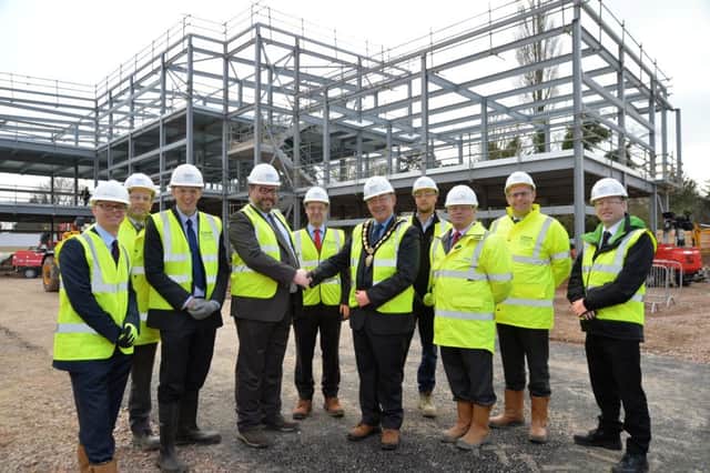 Topping out....centre, Dr Richard Palin chairman of East Leicestershire and Rutland Clinical Commissioning Group and councillor Michael Rook chairman of Harborough District Council with St Luke's hospital behing them.
PICTURE: ANDREW CARPENTER