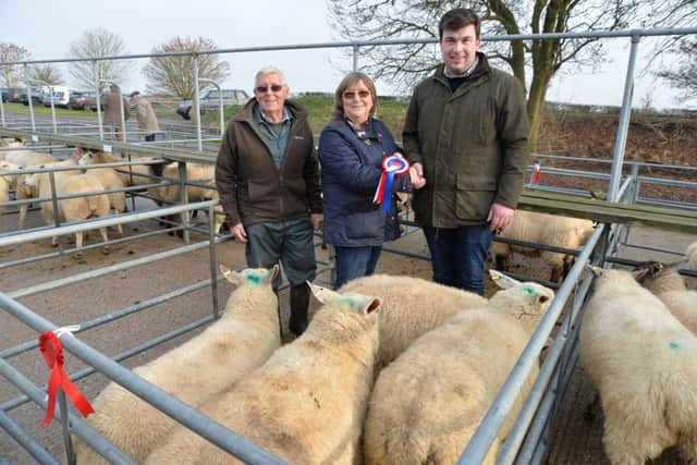 Judge Josh Bustance presents David and Helen Stokes of Drayton for the best of four charolais cross sheep during the Market Harborough christmas fatstock show at Foxton market.
PICTURE: ANDREW CARPENTER